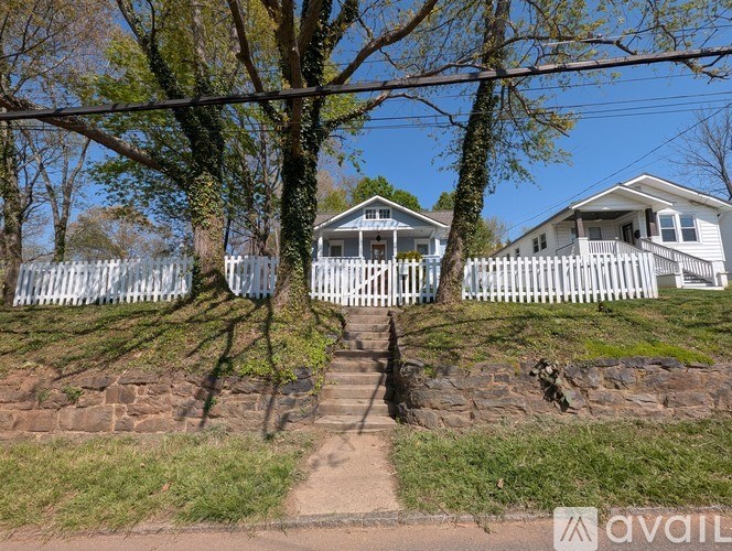 A house with a white picket fence is in the image.