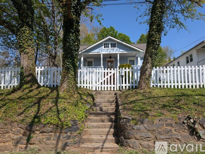 A house with a white picket fence and stairs leading up to it.