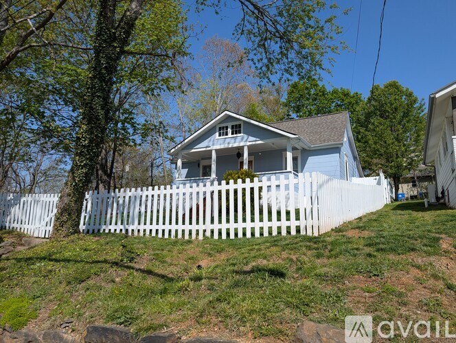 A house with a white picket fence in front of it.