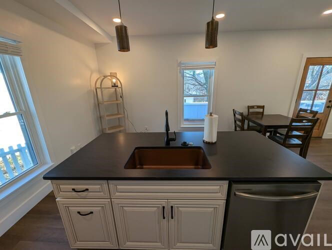 A kitchen with a black countertop and white cabinets.