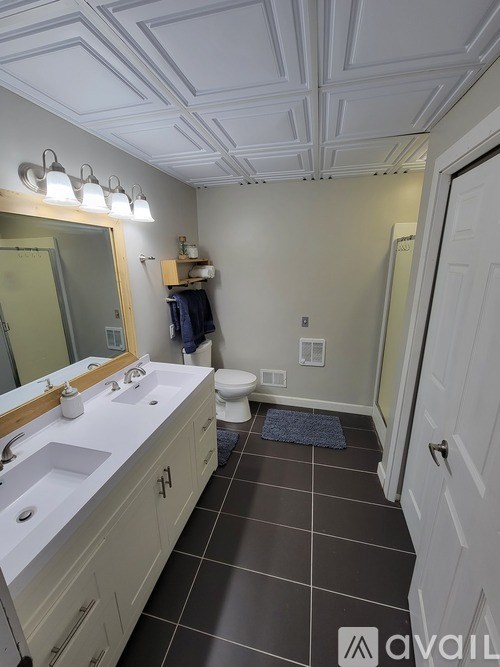 A bathroom with a white sink and a mirror.