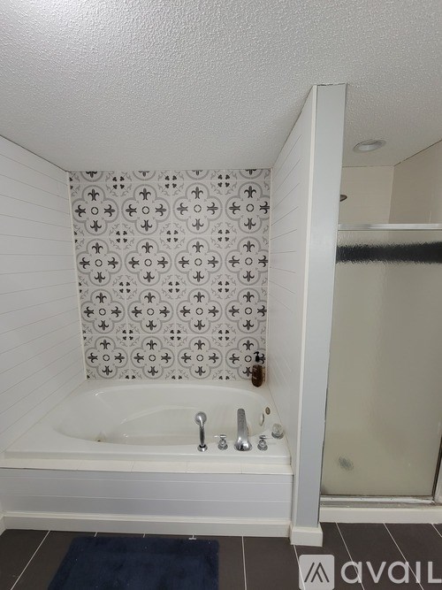 A white bathroom with a patterned shower curtain.