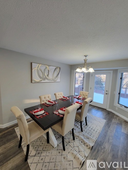 A dining room with a black table and chairs.