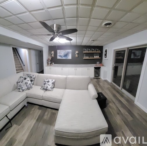 A living room with a white couch and a ceiling fan.