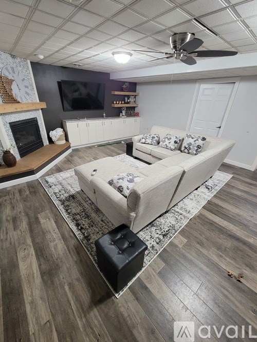 A living room with a white couch and a fireplace.