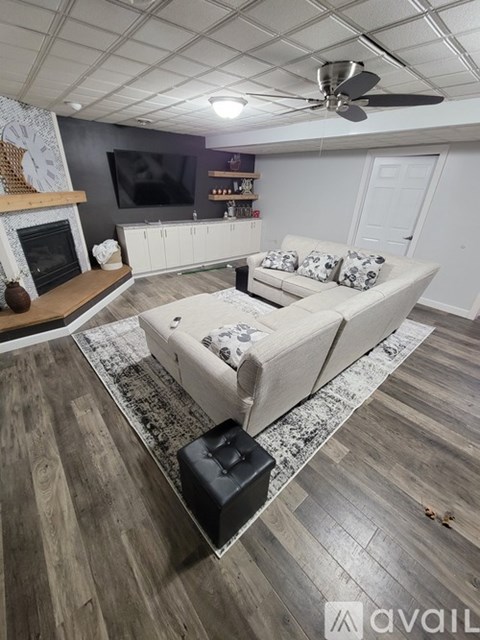 A living room with a white couch and a fireplace.