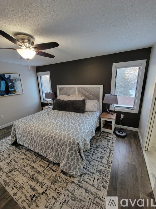 A bedroom with a bed, nightstand, and window.