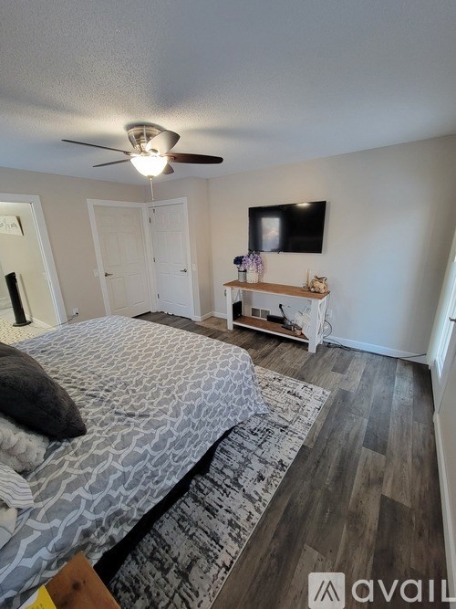 A bedroom with a large bed and a flat screen TV mounted on the wall.