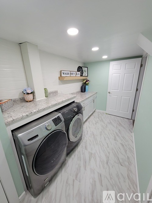 A laundry room with a washer and dryer built into the counter.