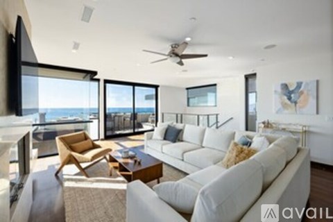 A living room with a white couch and a flat screen TV.