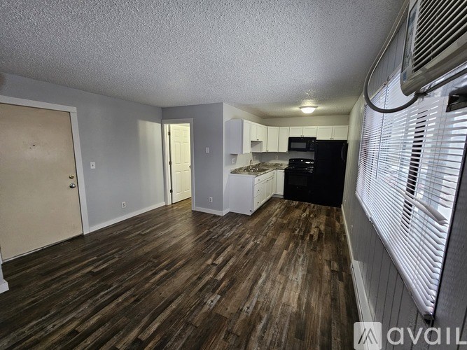 A kitchen area with wooden floors and white walls.
