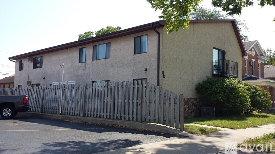 A beige house with a black truck parked in front.