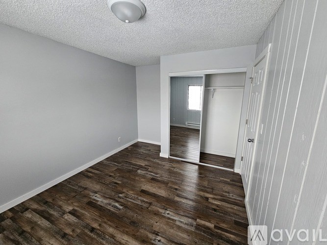 A room with wooden flooring and white walls.