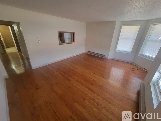 A room with wooden flooring and a window.