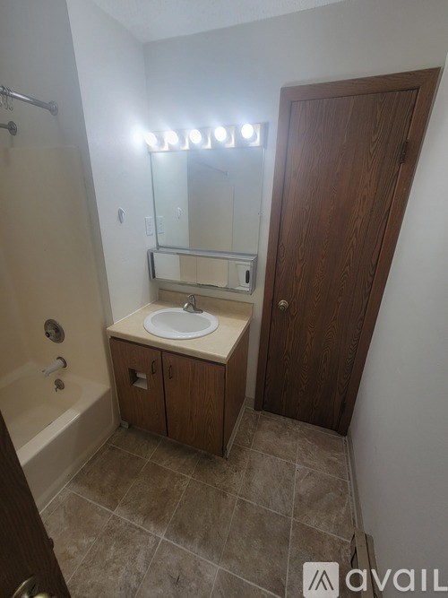 A bathroom with a sink, mirror, and shower.
