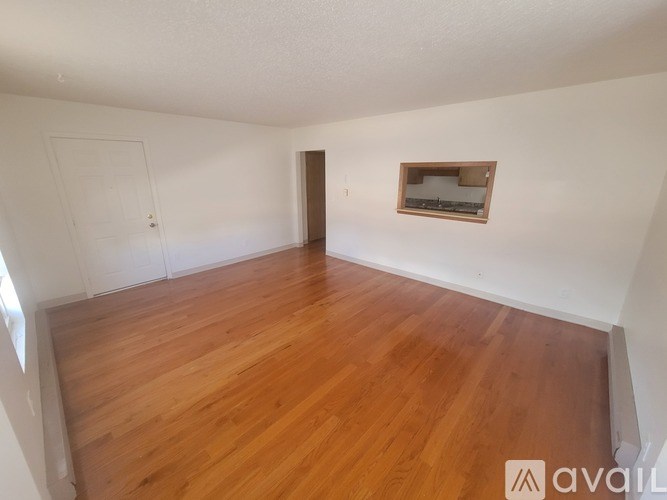 A room with wooden flooring and a window.