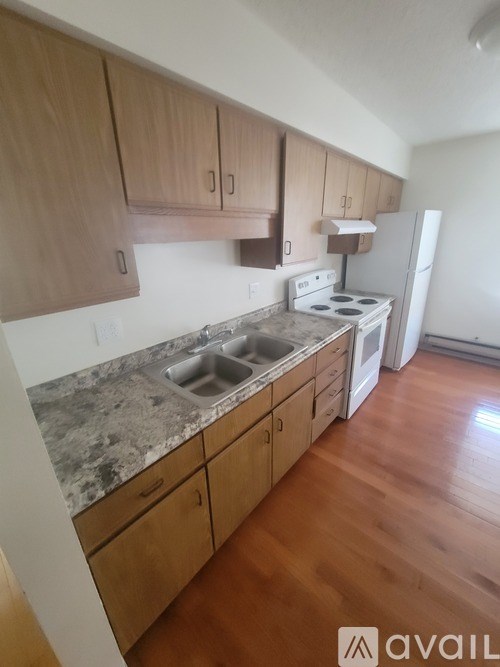 A kitchen with wooden cabinets and a marble countertop.