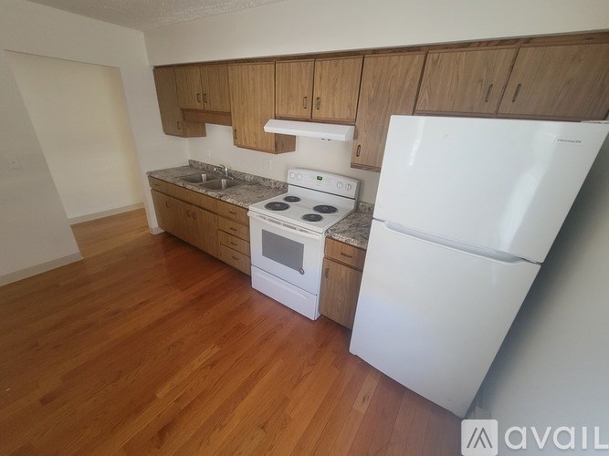 A kitchen with a white fridge and stove top oven.
