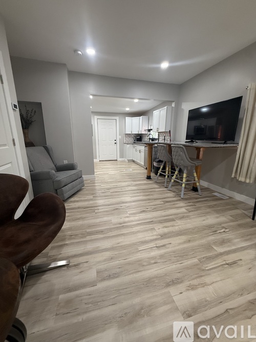 A living room with a grey couch and a wooden floor.