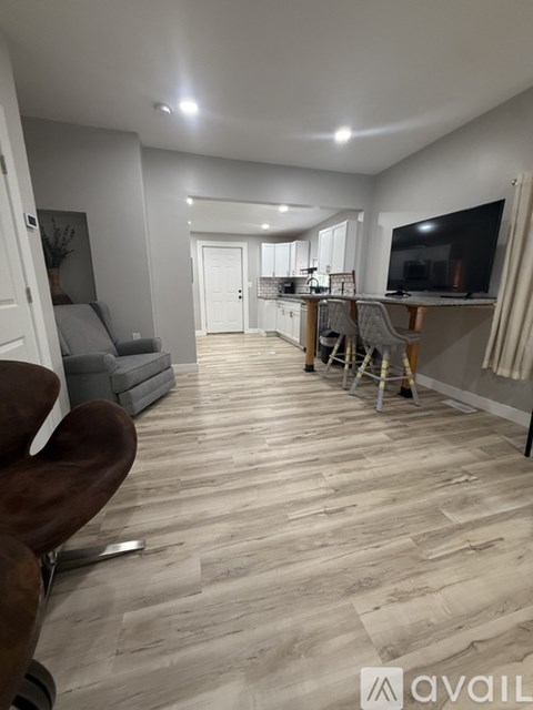 A living room with a grey couch and a wooden floor.