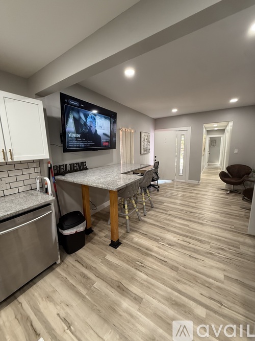A living room with a dining area and a kitchen in the background.