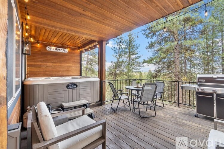 A wooden deck with a hot tub and chairs.
