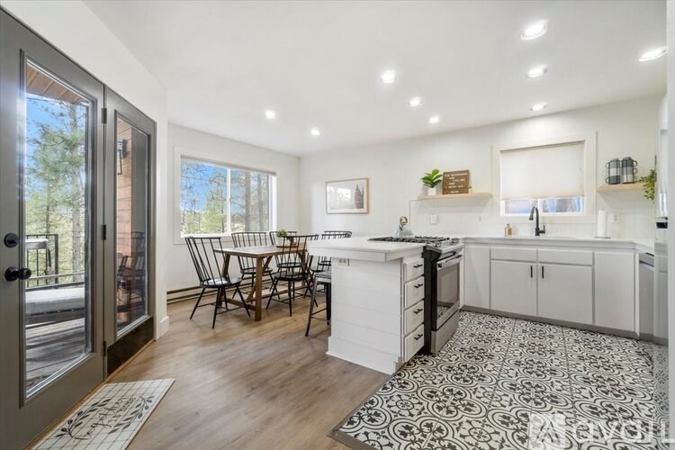 A modern kitchen with a dining table and chairs.