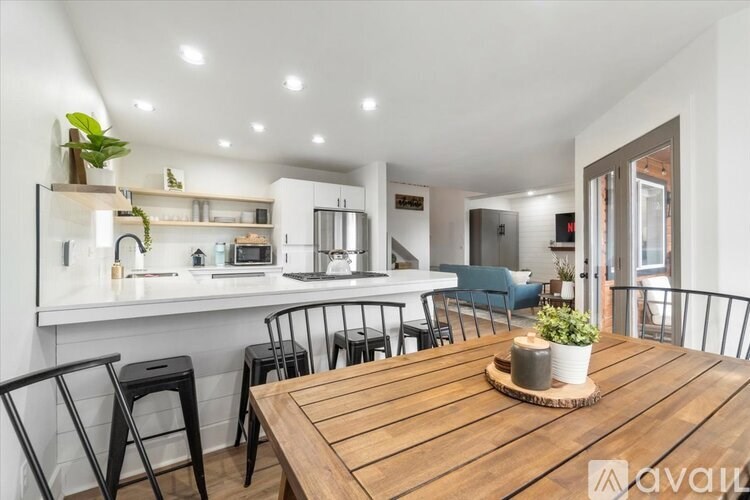 A modern kitchen with a wooden table and chairs.