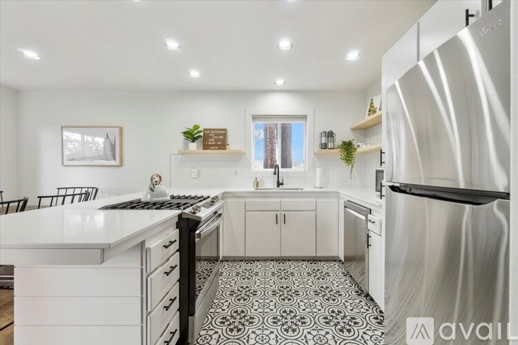 A modern kitchen with a black and white patterned floor.
