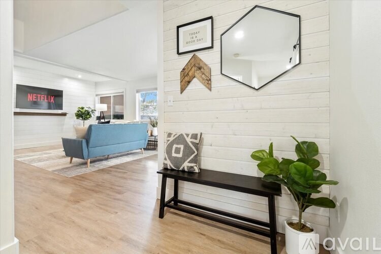 A living room with a blue couch and a wooden bench.