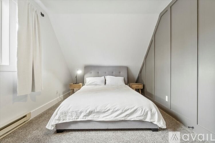 A bedroom with a large bed and a carpeted floor.