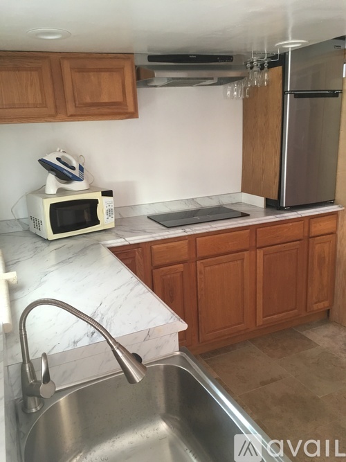 A kitchen with a sink, microwave, and refrigerator.