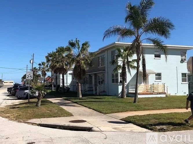 A blue house with a palm tree in front.