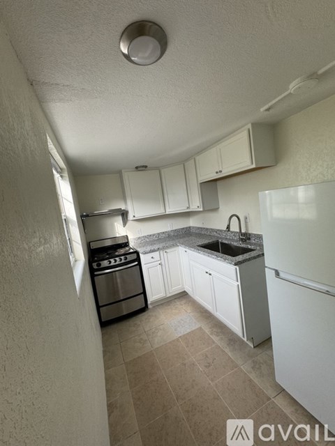 A kitchen with white cabinets and a black stove top oven.