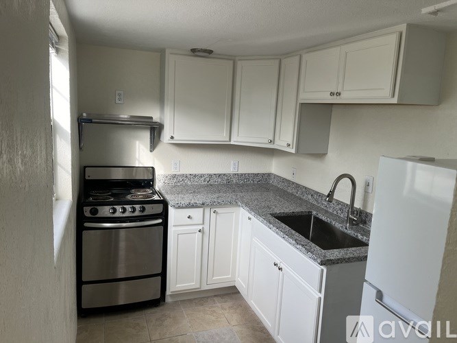 A kitchen with white cabinets and a stainless steel oven.