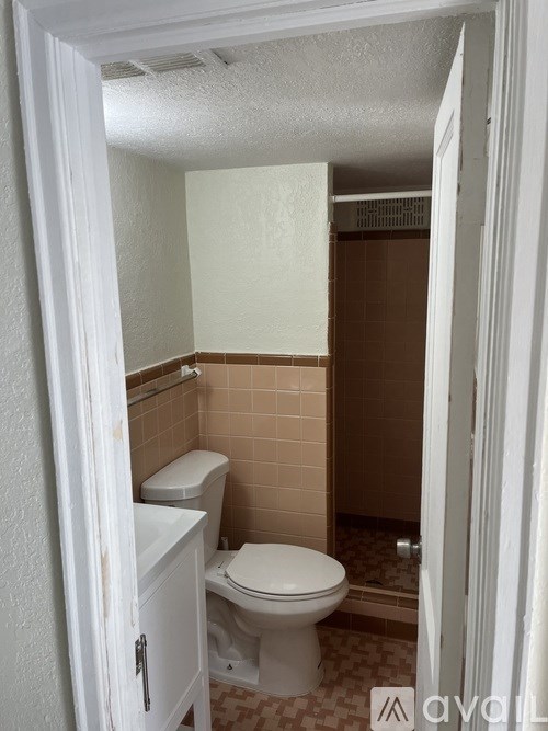 A small bathroom with a toilet and a cabinet.