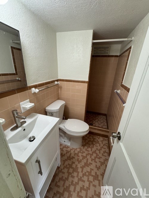 A bathroom with a toilet, sink, and shower.