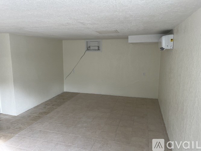 A room with a tiled floor and a wall-mounted air conditioner unit.