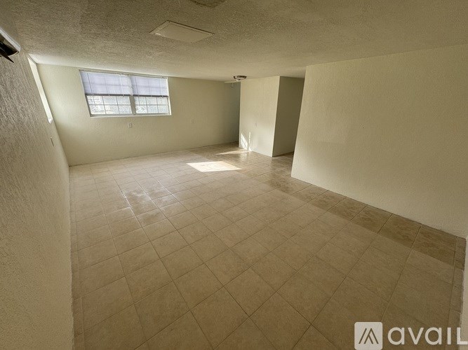 A spacious room with tiled flooring and a window.