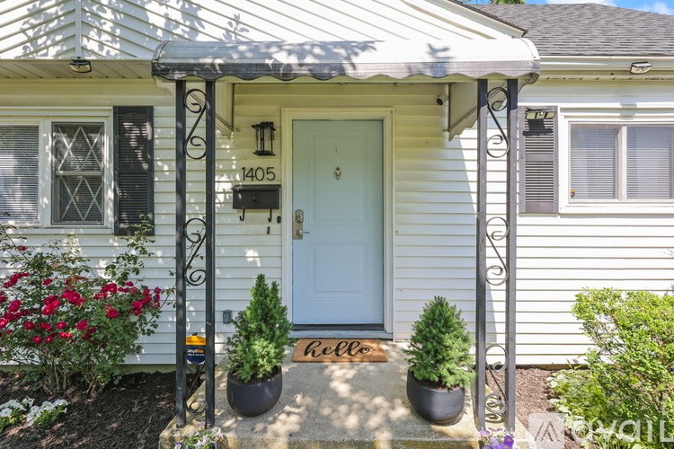 A white house with a blue door and a mailbox that reads 1405.