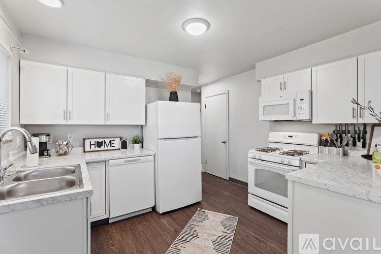 A kitchen with white appliances and cabinets.