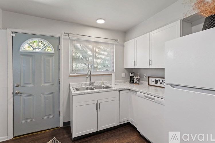 A kitchen with white cabinets and a blue door.