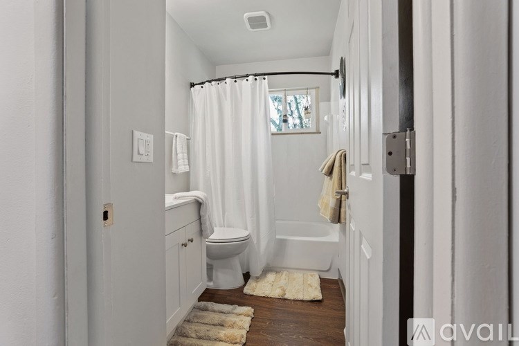 A white bathroom with a toilet, sink, and bathtub.