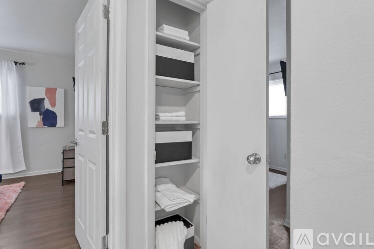A white closet with beds and towels inside.