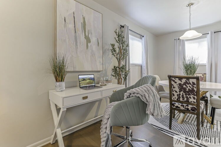 A white desk with a laptop and a plant on it.