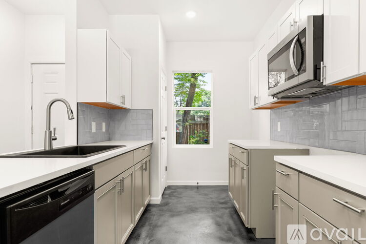 A kitchen with white cabinets and black appliances.