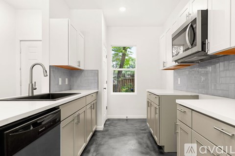 A kitchen with white cabinets and black appliances.