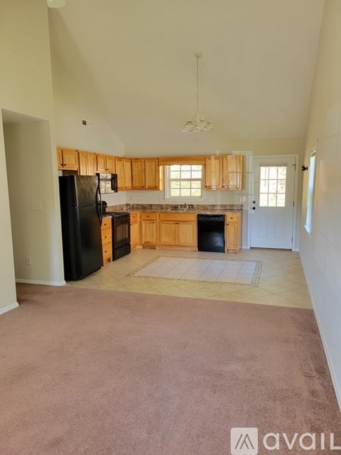 A kitchen with wooden cabinets and black appliances.