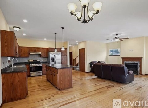 A spacious kitchen with wooden cabinets and a black countertop.