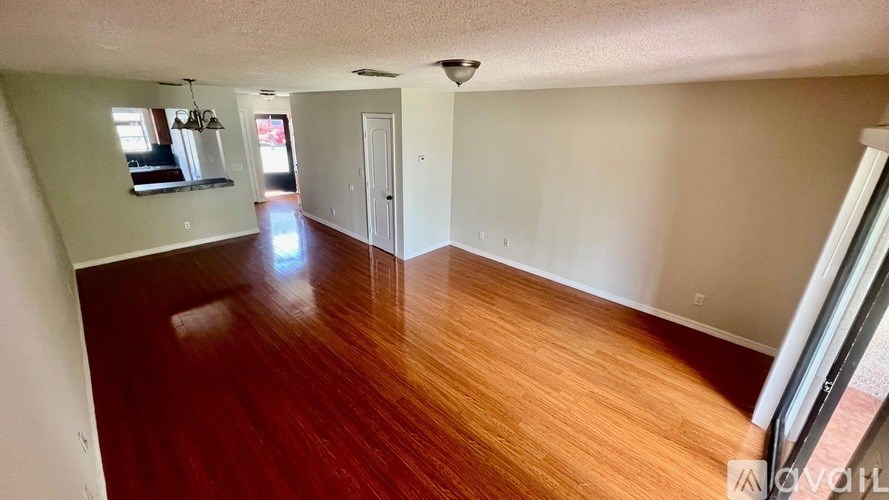 A room with wooden flooring and white walls.